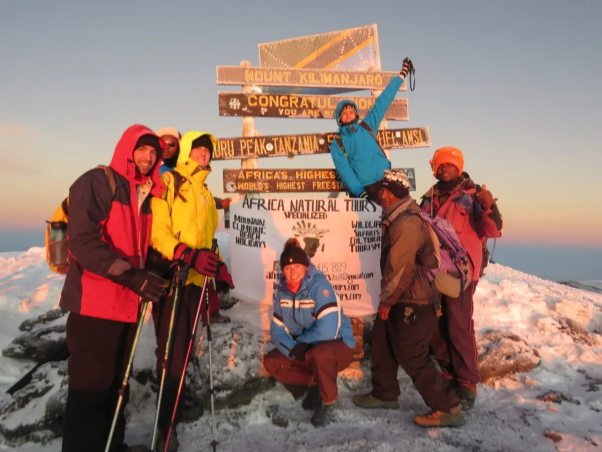 Alpinistes devant le panneau du sommet
